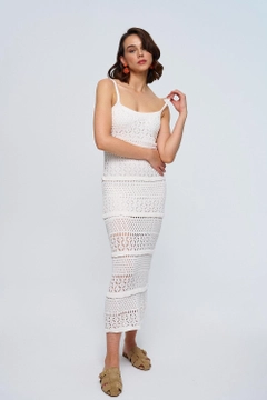 Bir model, Tuba Butik toptan giyim markasının tbu12779-strappy-openwork-midi-knitwear-dress-ecru toptan Elbise ürününü sergiliyor.
