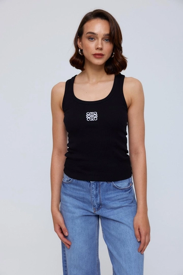 Bir model, Tuba Butik toptan giyim markasının  Nakış Detaylı Fitilli Kadın Atlet - Siyah
 toptan Atlet ürününü sergiliyor.