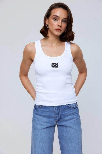 Bir model, Tuba Butik toptan giyim markasının  Nakış Detaylı Fitilli Kadın Atlet - Beyaz
 toptan Atlet ürününü sergiliyor.