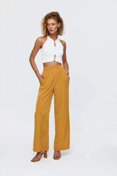 A wholesale clothing model wears tbu11781-women's-wide-leg-flowy-trousers-mustard, Turkish wholesale Pants of Tuba Butik