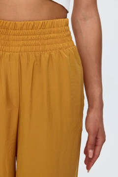 A wholesale clothing model wears tbu11781-women's-wide-leg-flowy-trousers-mustard, Turkish wholesale Pants of Tuba Butik