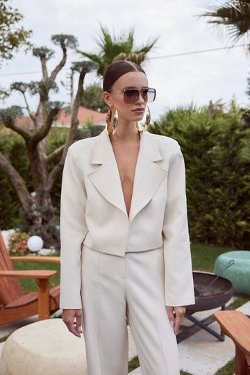 Bir model, Tuba Butik toptan giyim markasının  Vatkalı Blazer Crop Kadın Ceket - Ekru
 toptan Ceket ürününü sergiliyor.