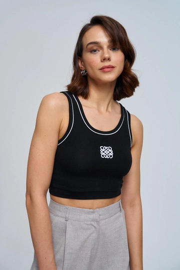 Bir model, Tuba Butik toptan giyim markasının  Nakışlı Kadın Crop Atlet - Siyah
 toptan Atlet ürününü sergiliyor.