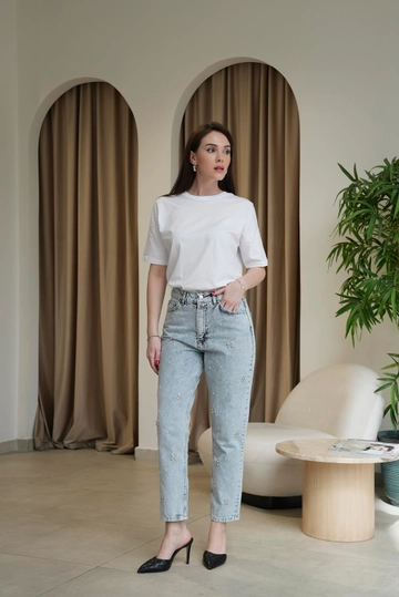 Bir model, Tuba Butik toptan giyim markasının  Yüksek Bel Taş Detaylı Mom Kadın Kot Pantolon - Mavi
 toptan Kot Pantolon ürününü sergiliyor.