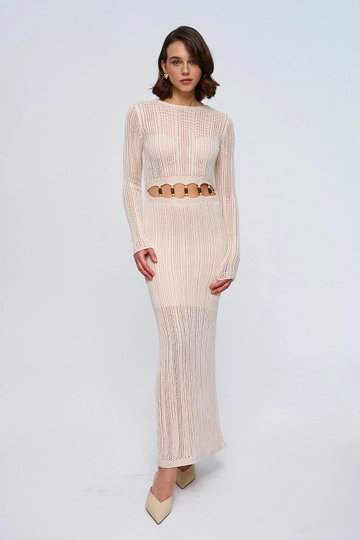 Bir model, Tuba Butik toptan giyim markasının  Bel Detaylı Ajurlu Uzun Triko Elbise - Krem
 toptan Elbise ürününü sergiliyor.