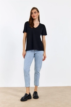 Bir model, Tuba Butik toptan giyim markasının TBU10445 - Women's V-Neck Short Sleeve T-Shirt - Black toptan Tişört ürününü sergiliyor.