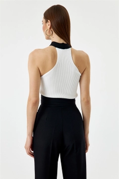 Bir model, Tuba Butik toptan giyim markasının TBU10610 - Women's Cross-Strap Knitwear Blouse - White toptan Bluz ürününü sergiliyor.