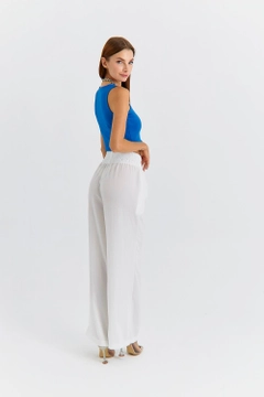 Una modelo de ropa al por mayor lleva TBU11762 - Women's Wide Leg Flowy Trousers - White, Pantalón turco al por mayor de Tuba Butik