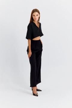 Ein Bekleidungsmodell aus dem Großhandel trägt TBU11764 - Women's Wide Leg Flowy Trousers - Black, türkischer Großhandel Hose von Tuba Butik