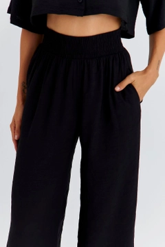 Модел на дрехи на едро носи TBU11764 - Women's Wide Leg Flowy Trousers - Black, турски едро Панталони на Tuba Butik