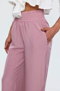 Una modella di abbigliamento all'ingrosso indossa TBU11768 - Women's Wide Leg Flowy Trousers - Dried Rose, vendita all'ingrosso turca di Pantaloni di Tuba Butik
