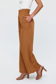 Una modelo de ropa al por mayor lleva tbu11771-wide-leg-flowy-tan-women's-trousers-camel, Pantalón turco al por mayor de Tuba Butik
