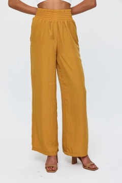 Ένα μοντέλο χονδρικής πώλησης ρούχων φοράει tbu11781-women's-wide-leg-flowy-trousers-mustard, τούρκικο Παντελόνι χονδρικής πώλησης από Tuba Butik