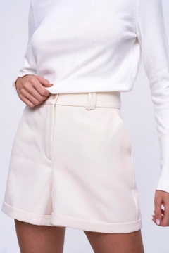 Una modella di abbigliamento all'ingrosso indossa tbu11947-women's-high-waist-bermuda-shorts-ecru, vendita all'ingrosso turca di Pantaloncini di Tuba Butik
