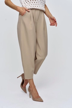 Un mannequin de vêtements en gros porte tbu11974-pleated-shalwar-women's-trousers-mink, Pantalon en gros de Tuba Butik en provenance de Turquie