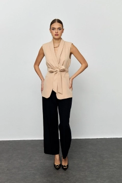Ένα μοντέλο χονδρικής πώλησης ρούχων φοράει tbu12181-belted-tuxedo-collar-women's-vest-beige, τούρκικο Αμάνικο μπλουζάκι χονδρικής πώλησης από Tuba Butik