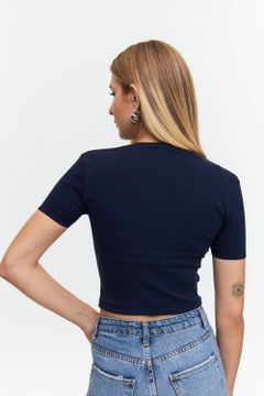 Bir model, Tuba Butik toptan giyim markasının tbu12502-basic-crew-neck-short-sleeve-women's-crop-navy-blue toptan Crop Top ürününü sergiliyor.