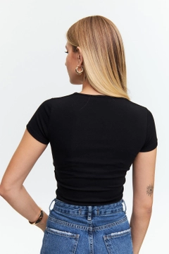 Bir model, Tuba Butik toptan giyim markasının tbu12567-square-neck-short-sleeve-women's-crop-black toptan Crop Top ürününü sergiliyor.