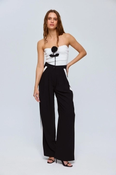 Bir model, Tuba Butik toptan giyim markasının tbu12611-stripe-detailed-palazzo-women's-trousers-black toptan Pantolon ürününü sergiliyor.
