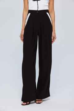 Bir model, Tuba Butik toptan giyim markasının tbu12611-stripe-detailed-palazzo-women's-trousers-black toptan Pantolon ürününü sergiliyor.