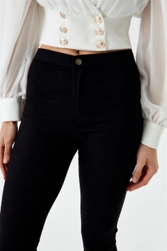 Bir model, Tuba Butik toptan giyim markasının tbu12694-high-waist-lycra-skinny-women's-jeans-black toptan Kot Pantolon ürününü sergiliyor.