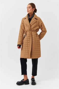Bir model, Tuba Butik toptan giyim markasının TBU10317 - Modest Quilted Long Belt Slim Women's Jacket - Light Brown toptan Ceket ürününü sergiliyor.