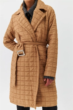 Una modella di abbigliamento all'ingrosso indossa TBU10317 - Modest Quilted Long Belt Slim Women's Jacket - Light Brown, vendita all'ingrosso turca di Giacca di Tuba Butik