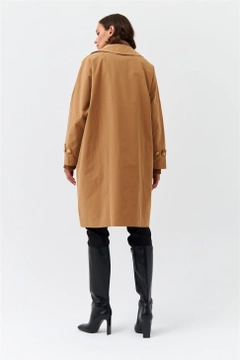 Bir model, Tuba Butik toptan giyim markasının 36379 - Trenchcoat - Camel toptan Trençkot ürününü sergiliyor.
