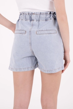 Bir model, XLove toptan giyim markasının 37356 - Denim Shorts - Light Blue toptan Kot Şort ürününü sergiliyor.