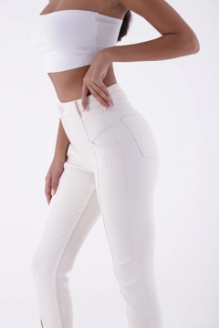 Bir model, XLove toptan giyim markasının XLO10002 - Jeans - Natural toptan Kot Pantolon ürününü sergiliyor.