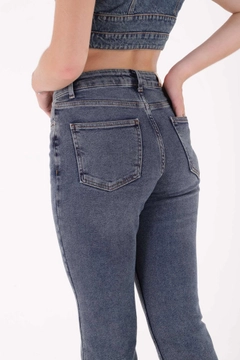 Bir model, XLove toptan giyim markasının xlo10116-tasseled-high-waist-mom-fit-jean-blue toptan Kot Pantolon ürününü sergiliyor.
