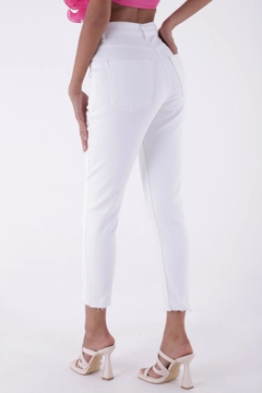 Bir model, XLove toptan giyim markasının xlo10146-slit-jeans-white toptan Kot Pantolon ürününü sergiliyor.
